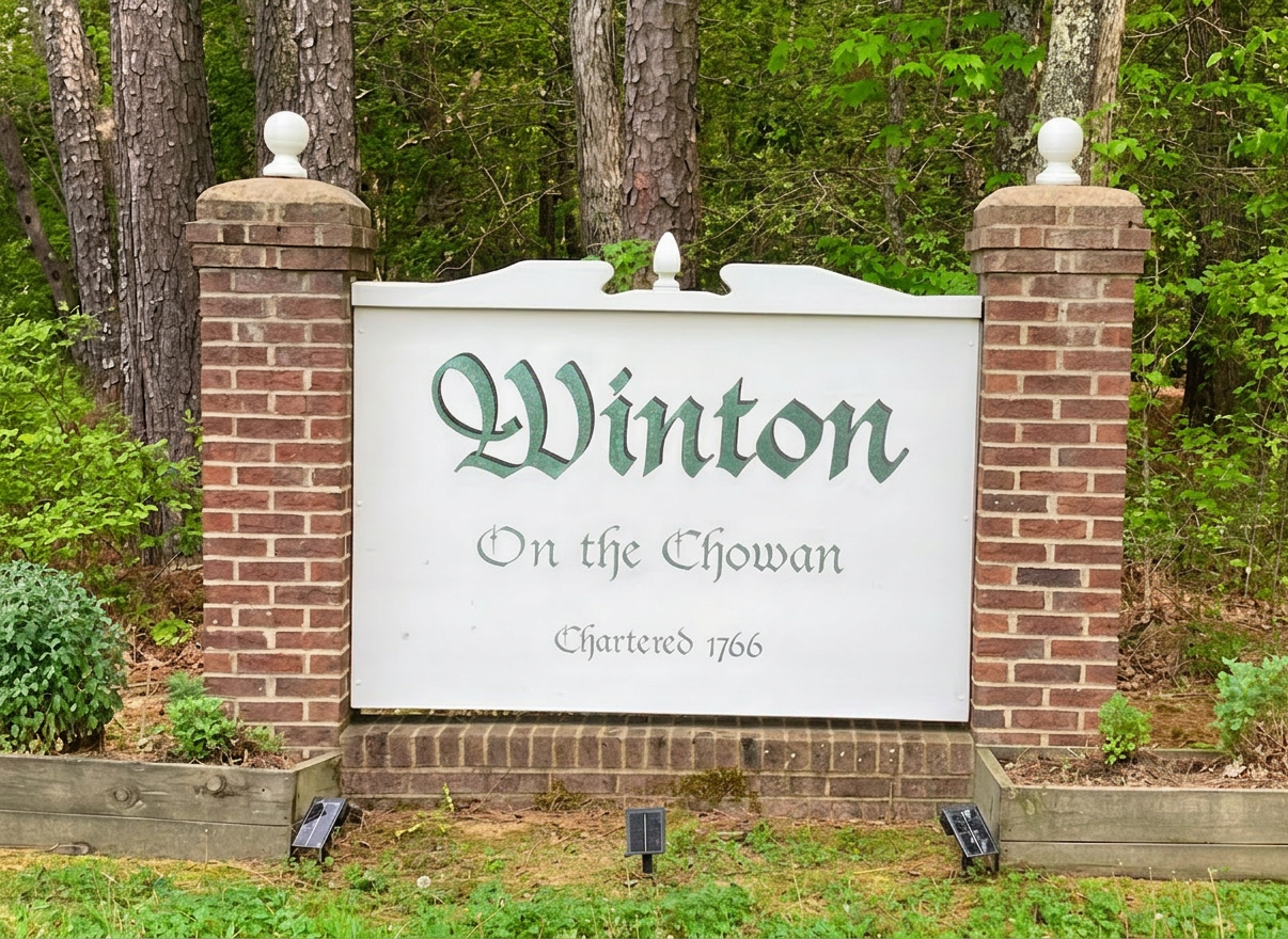 IMG_3633 Increase the contrast and darkness of the word "Winton" on this town welcome sign so that the lettering stands out more clearly, while keeping the rest of the photo natural and unchanged.